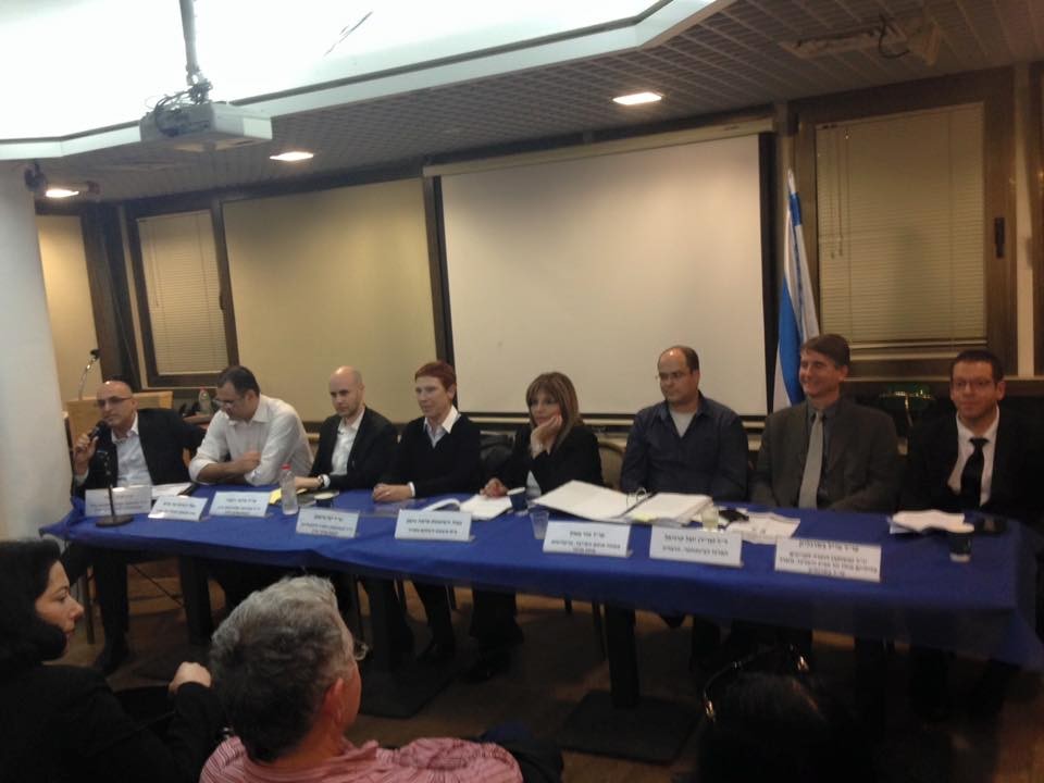 Panel of 8 official speakers before a live audience.